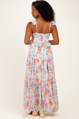 woman wearing a back view of a floral maxi dress with ruffled straps in pastel colors