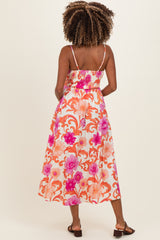 woman wearing a floral print maternity maxi dress with spaghetti straps and a smocked bodice, showing her baby bump