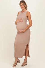 woman wearing a light beige ribbed maternity dress with a side slit, holding her baby bump