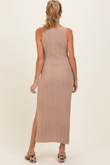 woman wearing a light pink ribbed maternity maxi dress with a side slit, showing a fitted silhouette from the back