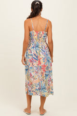 woman wearing a multicolor floral midi dress with adjustable spaghetti straps and smocked back details