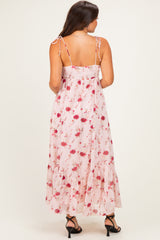 woman wearing a pink floral maternity maxi dress with back ties and ruffle hem