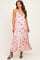 woman wearing a pink floral maternity maxi dress with adjustable straps and a flowing skirt, highlighting her baby bump