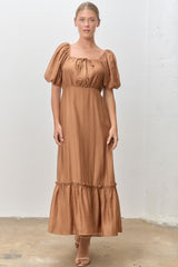 woman wearing a brown puff sleeve maxi dress with a square neckline and ruffled hem