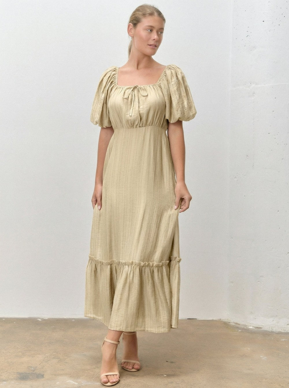 woman wearing a beige tiered maxi dress with puff sleeves and a square neckline