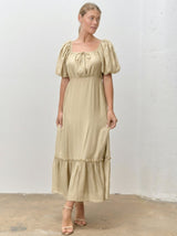 woman wearing a beige tiered maxi dress with puff sleeves and a square neckline
