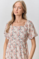 woman wearing a floral print short sleeve dress with a square neckline and soft, flowing fabric