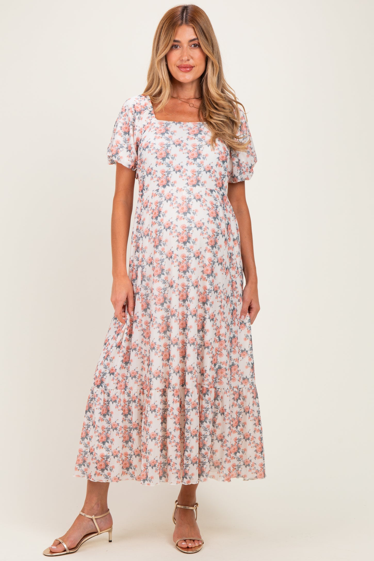 woman wearing a floral maternity maxi dress with short sleeves and a square neckline, showcasing her baby bump