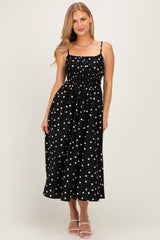 woman wearing a black midi dress with white polka dots and adjustable spaghetti straps