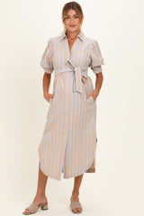 woman wearing a beige and blue striped maternity dress with puff sleeves and a tie waist, holding her baby bump