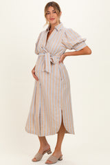 woman wearing a beige and blue striped maternity dress with puff sleeves and a tie waist, showing her baby bump