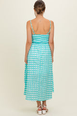 woman wearing a mint green maternity dress with a checkered pattern and smocked bodice, shown from the back