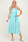 woman wearing a light blue and white checkered midi dress with spaghetti straps and a fitted bodice