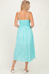 woman wearing a turquoise and white checkered midi dress with adjustable straps and a smocked back