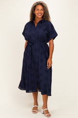 woman wearing a navy blue plus size midi dress with a belted waist and short sleeves, standing against a neutral background