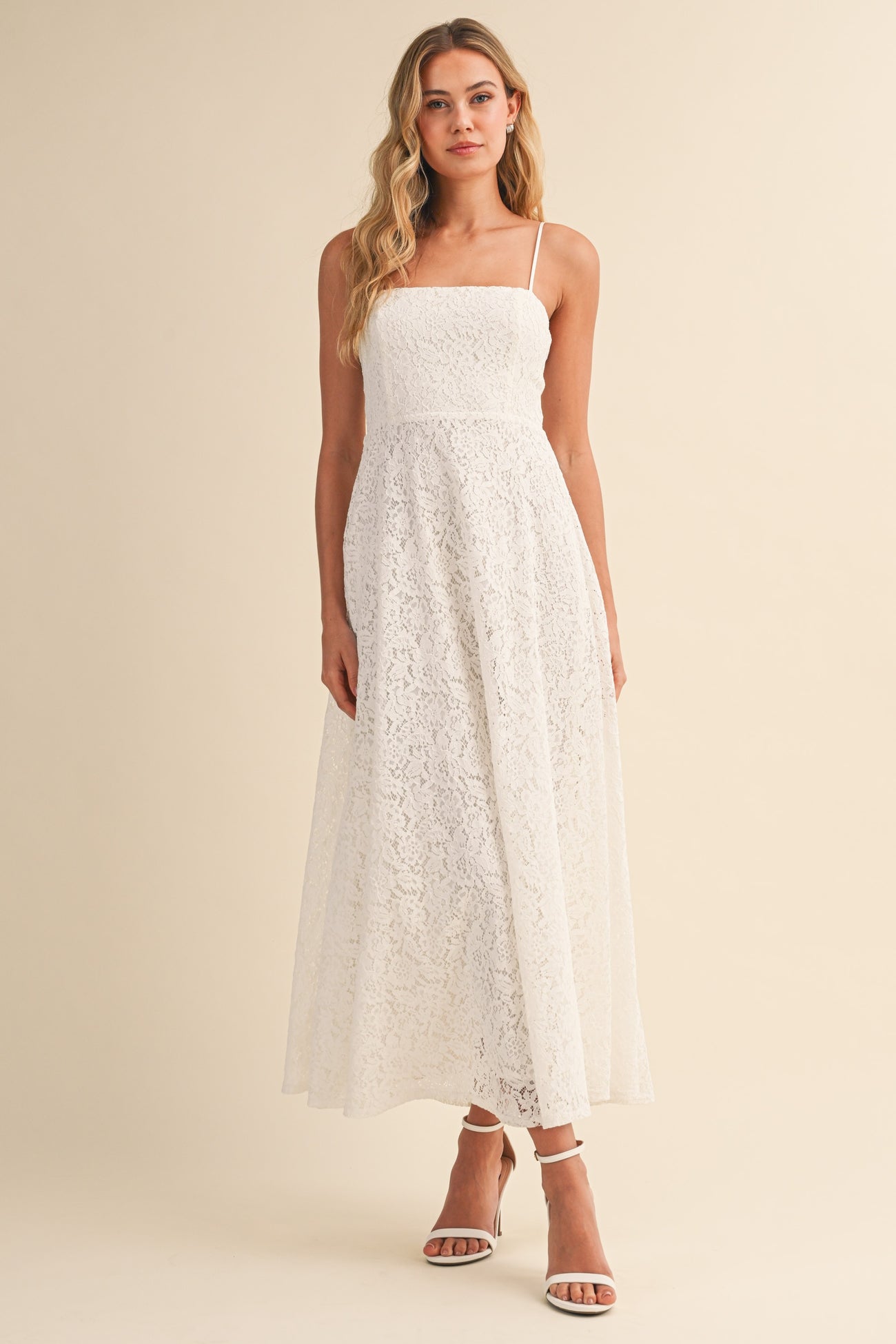 woman wearing a white lace maxi dress with spaghetti straps and a fitted bodice
