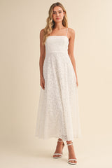 woman wearing a white lace maxi dress with spaghetti straps and a fitted bodice