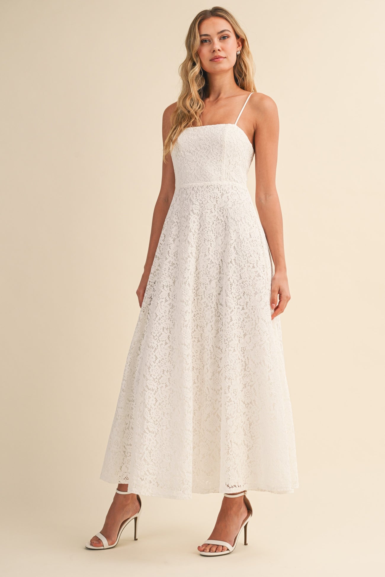 woman wearing a white lace maxi dress with spaghetti straps and a fitted bodice