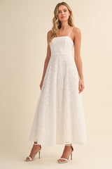 woman wearing a white lace maxi dress with spaghetti straps and a fitted bodice