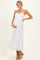 woman wearing a white lace maternity dress with spaghetti straps and holding her baby bump