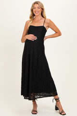 woman wearing a black lace maternity dress with a fitted bodice and flowing skirt, showing her baby bump