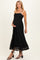 woman wearing a black lace maternity dress with spaghetti straps and a visible baby bump