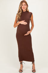 woman wearing a brown ribbed sleeveless maternity dress and holding her baby bump