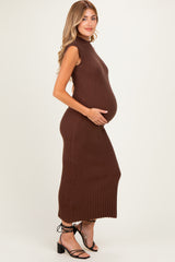 woman wearing a brown ribbed knit maternity dress with a mock neck and holding her baby bump