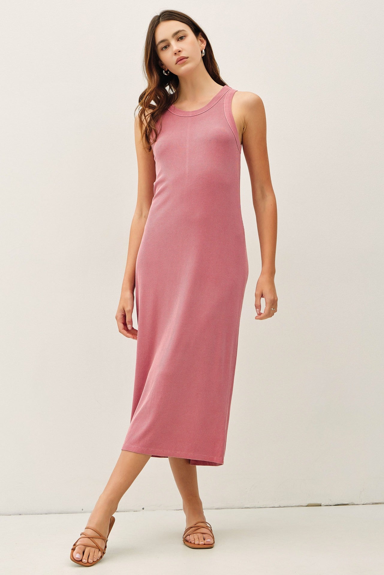 woman wearing a pink ribbed sleeveless midi dress with a relaxed fit and side slits