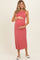 woman wearing a rose pink sleeveless maternity maxi dress and holding her baby bump