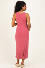 woman wearing a pink sleeveless maternity dress with a side slit, showing a relaxed fit from the back
