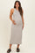 woman wearing a light gray maternity maxi dress and holding her baby bump