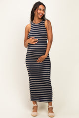 woman wearing a navy and white striped maternity maxi dress, gently holding her baby bump