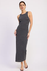 woman wearing a navy and cream striped maxi dress with a sleeveless design and a fitted silhouette