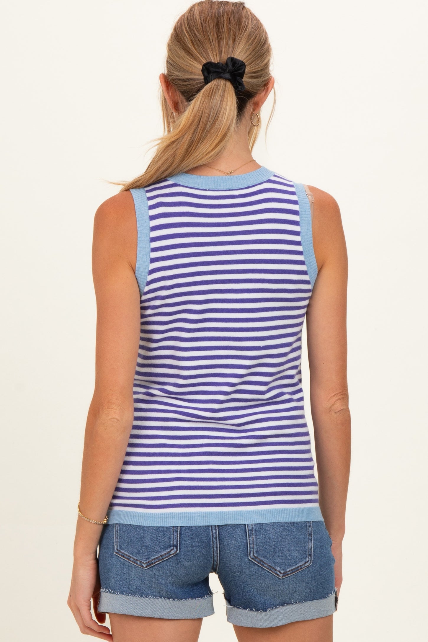 woman wearing a blue and white striped sleeveless maternity top with a relaxed fit and back view visible