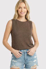 woman wearing a brown sleeveless top and distressed denim shorts