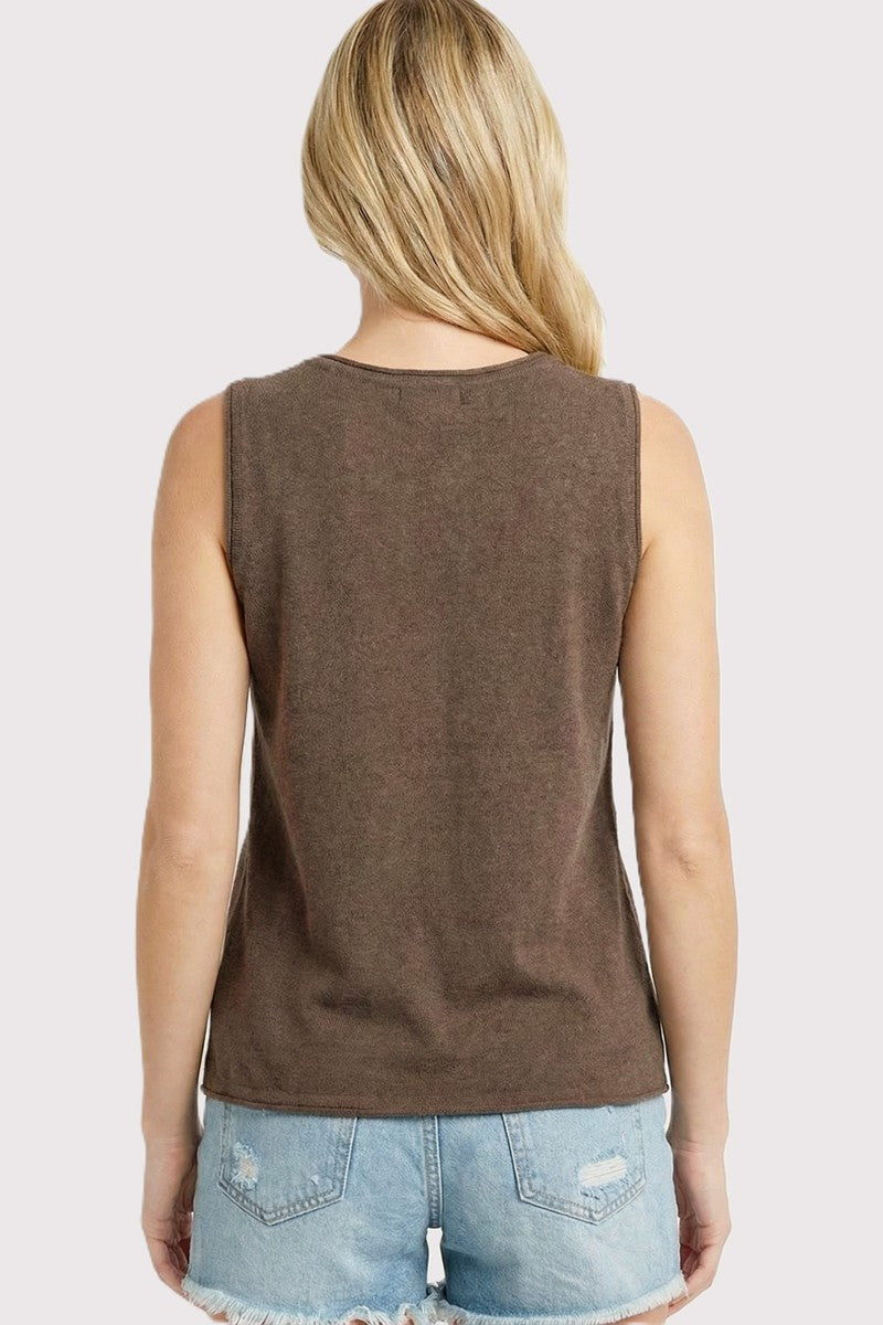 woman wearing a brown sleeveless top with a relaxed fit, paired with light blue denim shorts