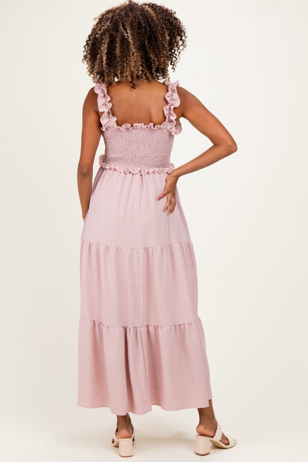 woman wearing a light pink maternity maxi dress with ruffle straps and smocked back detail