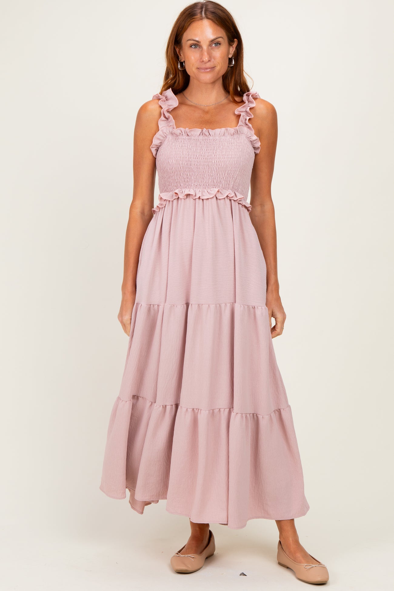 woman wearing a pink maxi dress with ruffled straps and a smocked bodice