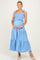 woman wearing a light blue maternity maxi dress with ruffle straps and tiered skirt, holding her baby bump