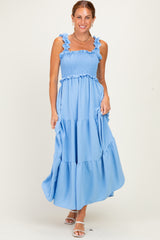 woman wearing a light blue tiered maxi dress with ruffled straps and a smocked bodice