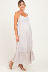 woman wearing a light pink maternity dress with spaghetti straps and eyelet details, showcasing her baby bump
