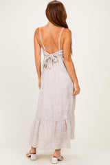 woman wearing a light lavender sleeveless maxi dress with a back tie detail and ruffled hem
