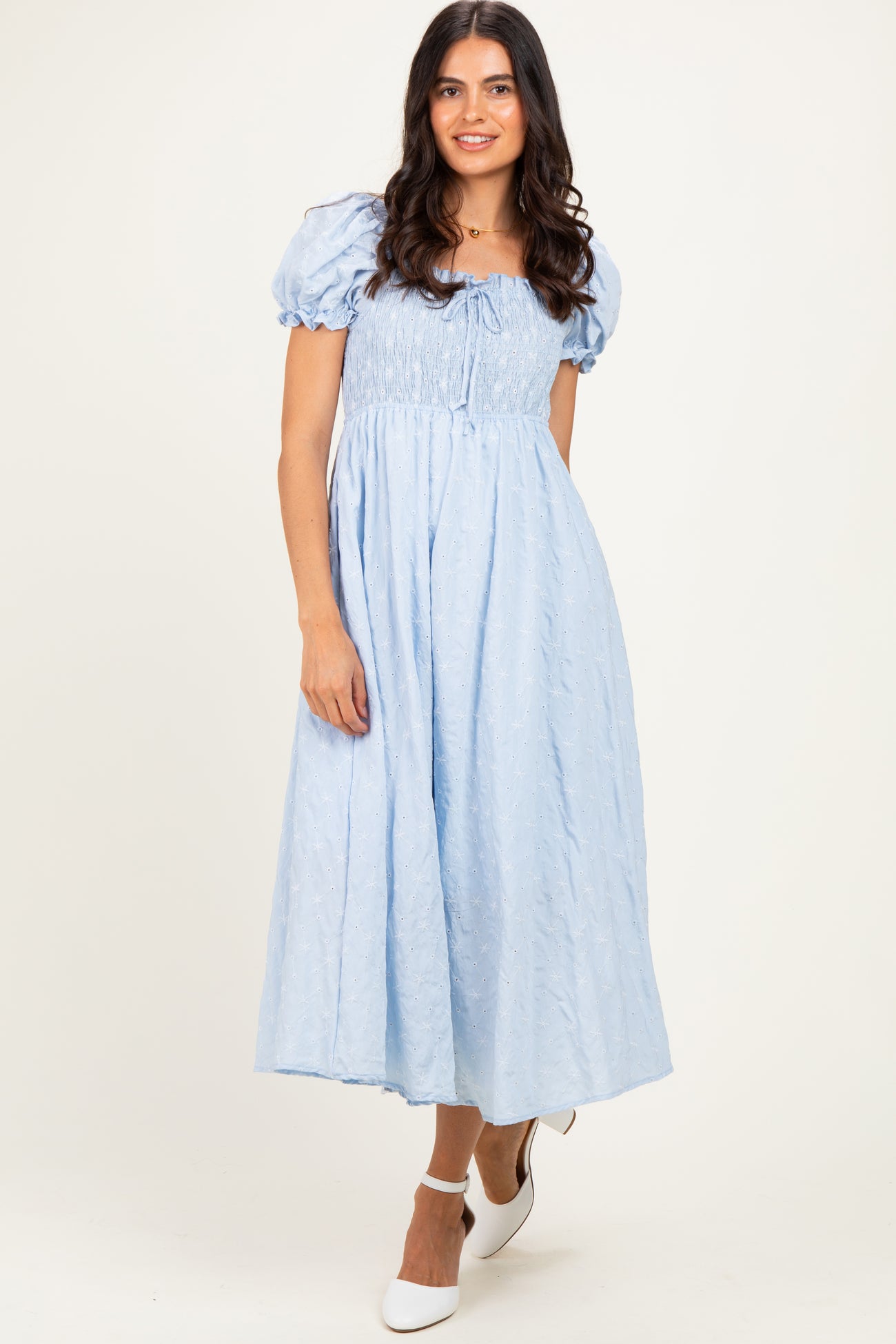 woman wearing a light blue puff sleeve maxi dress with a smocked bodice and tie detail