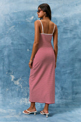woman wearing a striped red and white maxi dress with spaghetti straps and a fitted silhouette