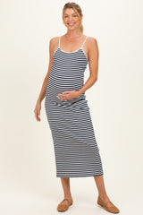 woman wearing a navy and white striped maternity maxi dress with spaghetti straps and a visible baby bump