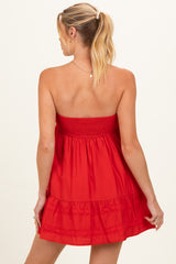 woman wearing a red strapless maternity dress with a smocked bodice and tiered ruffle skirt