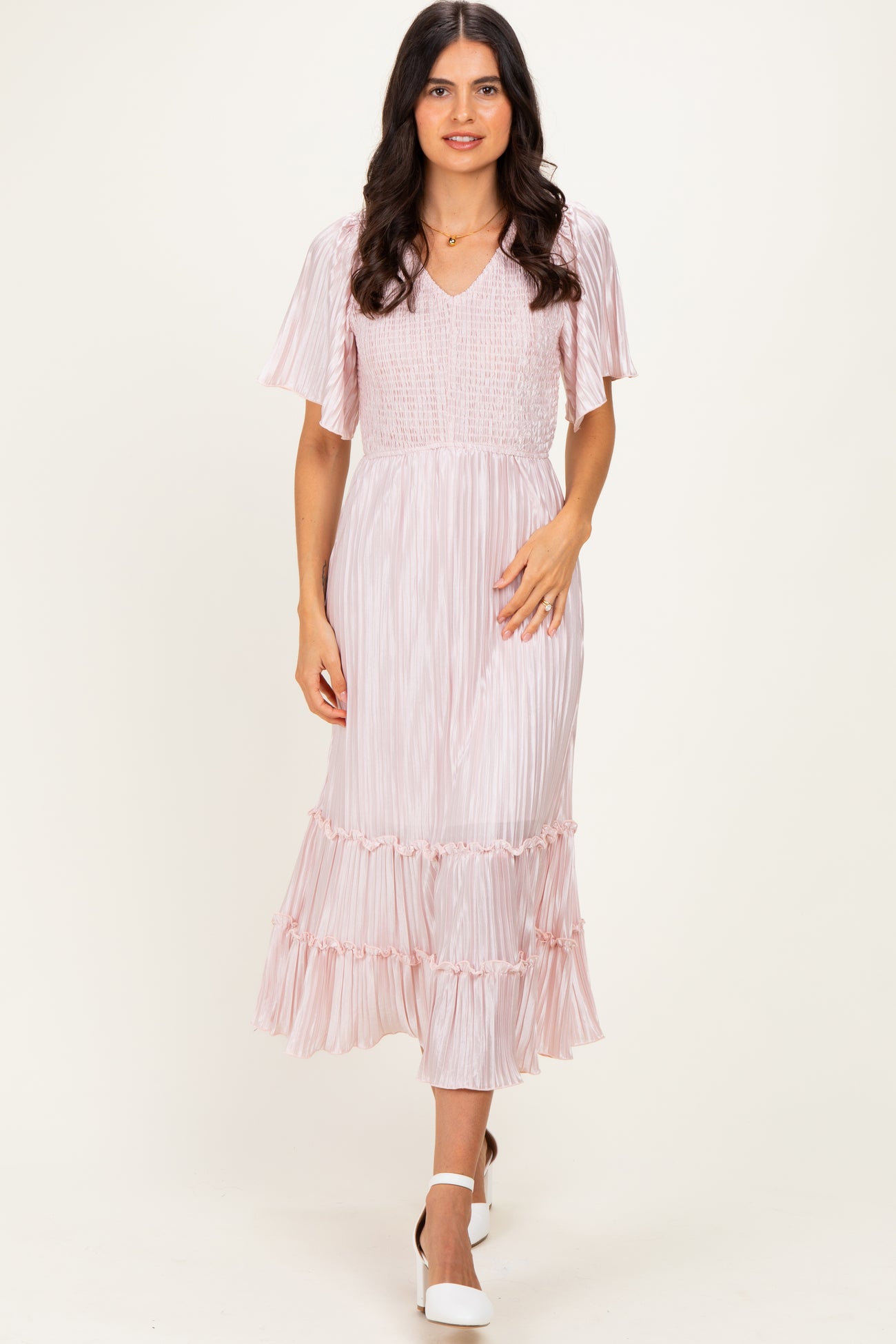 woman wearing a pink striped midi dress with flutter sleeves and a tiered ruffle hem