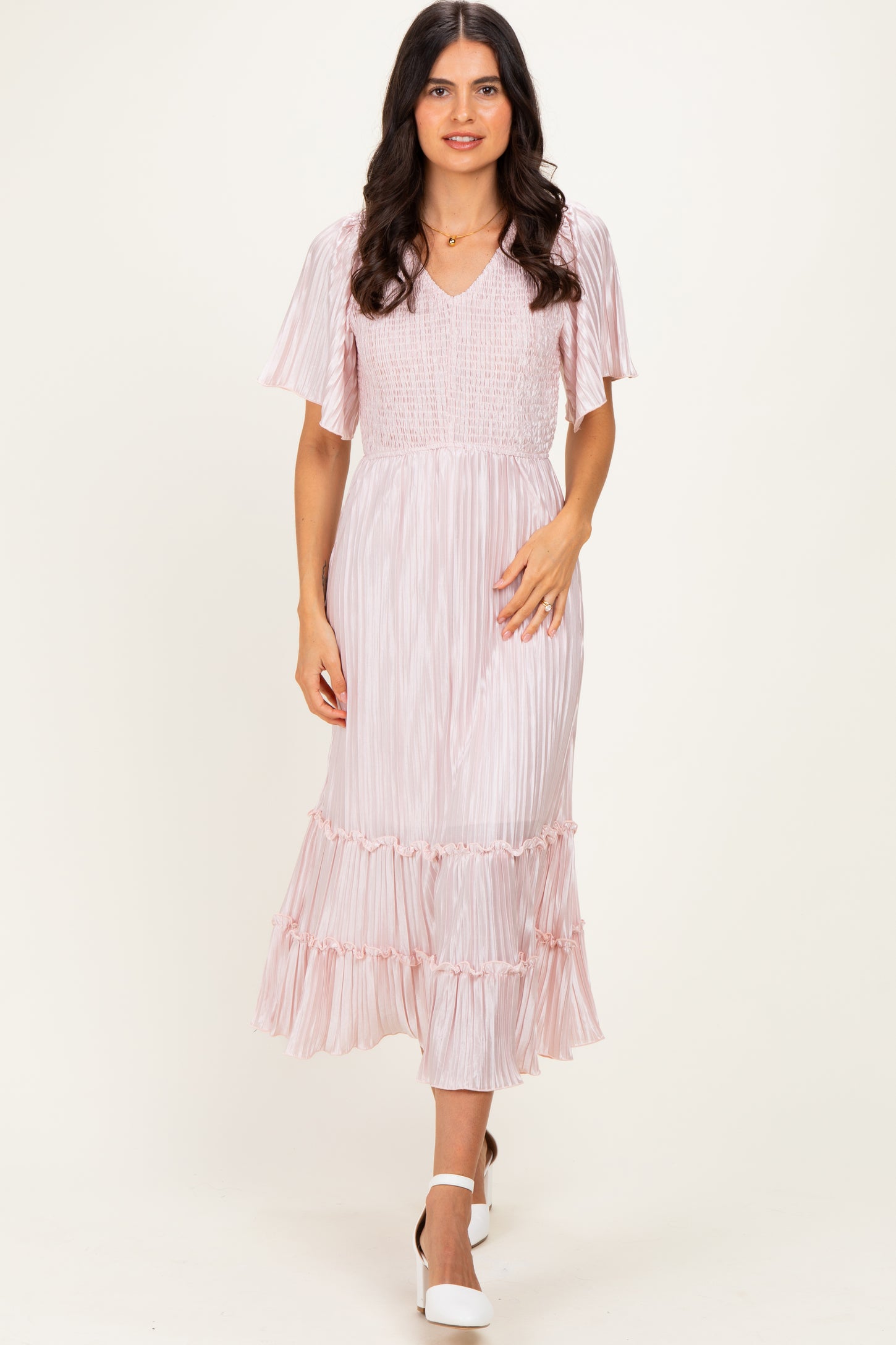 woman wearing a pink striped midi dress with flutter sleeves and a tiered ruffle hem