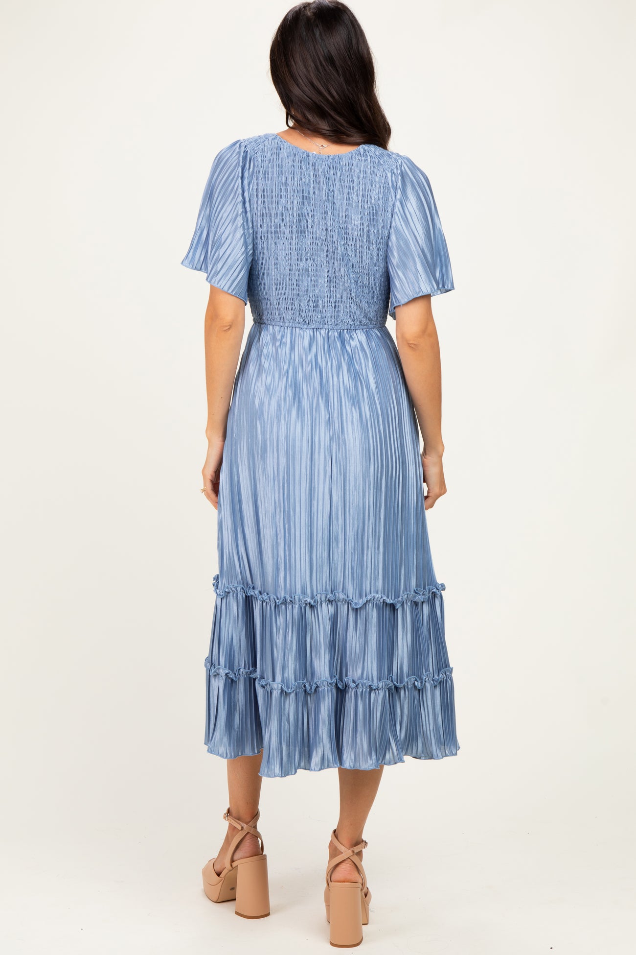 woman wearing a light blue midi dress with short sleeves and tiered ruffles, view of the back